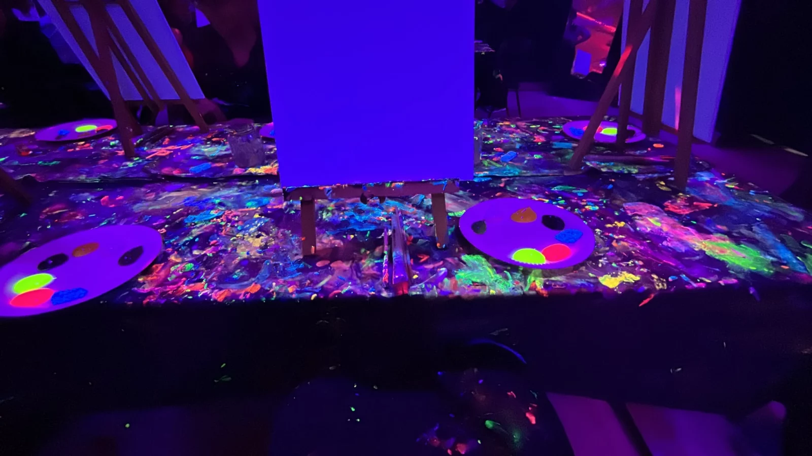 Canvas, palettes and neon paint during glow-in-the-dark painting in Amsterdam
